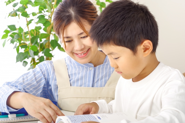 子供の勉強を見る女性スタッフ